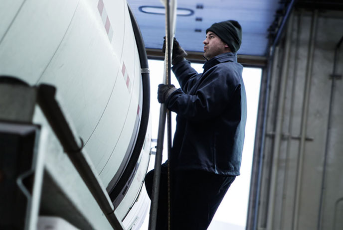 Image of man wearing FR clothing on oil truck