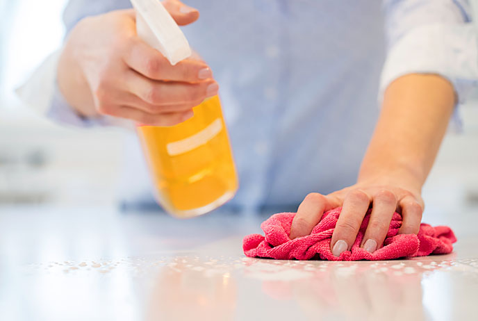 image of woman cleaning table top