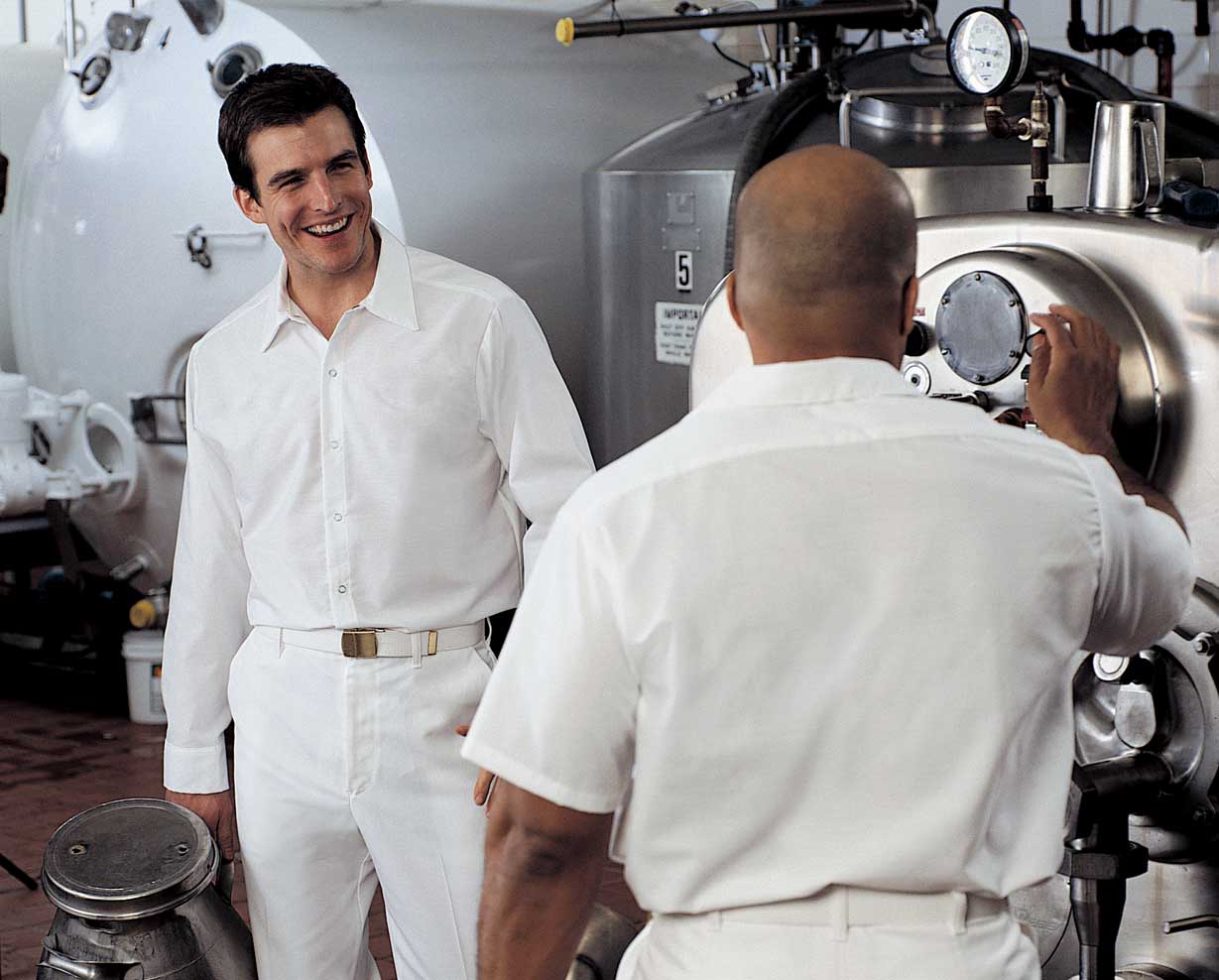 Two men in food processing plant wearing cook shirts